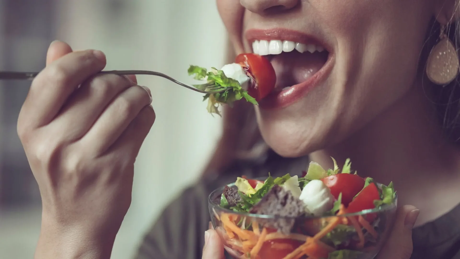 Mujer comiendo una ensalada tras la atención postquirúrgica con acompañamiento nutricional de NOVADENTAL
